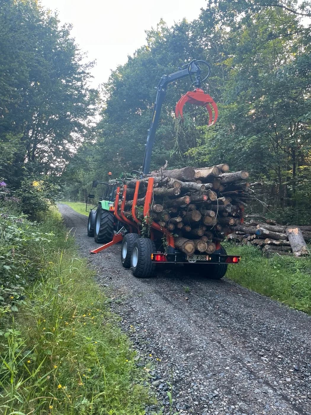 Hoch beladener Rückewagen auf einem schmalen Waldweg
