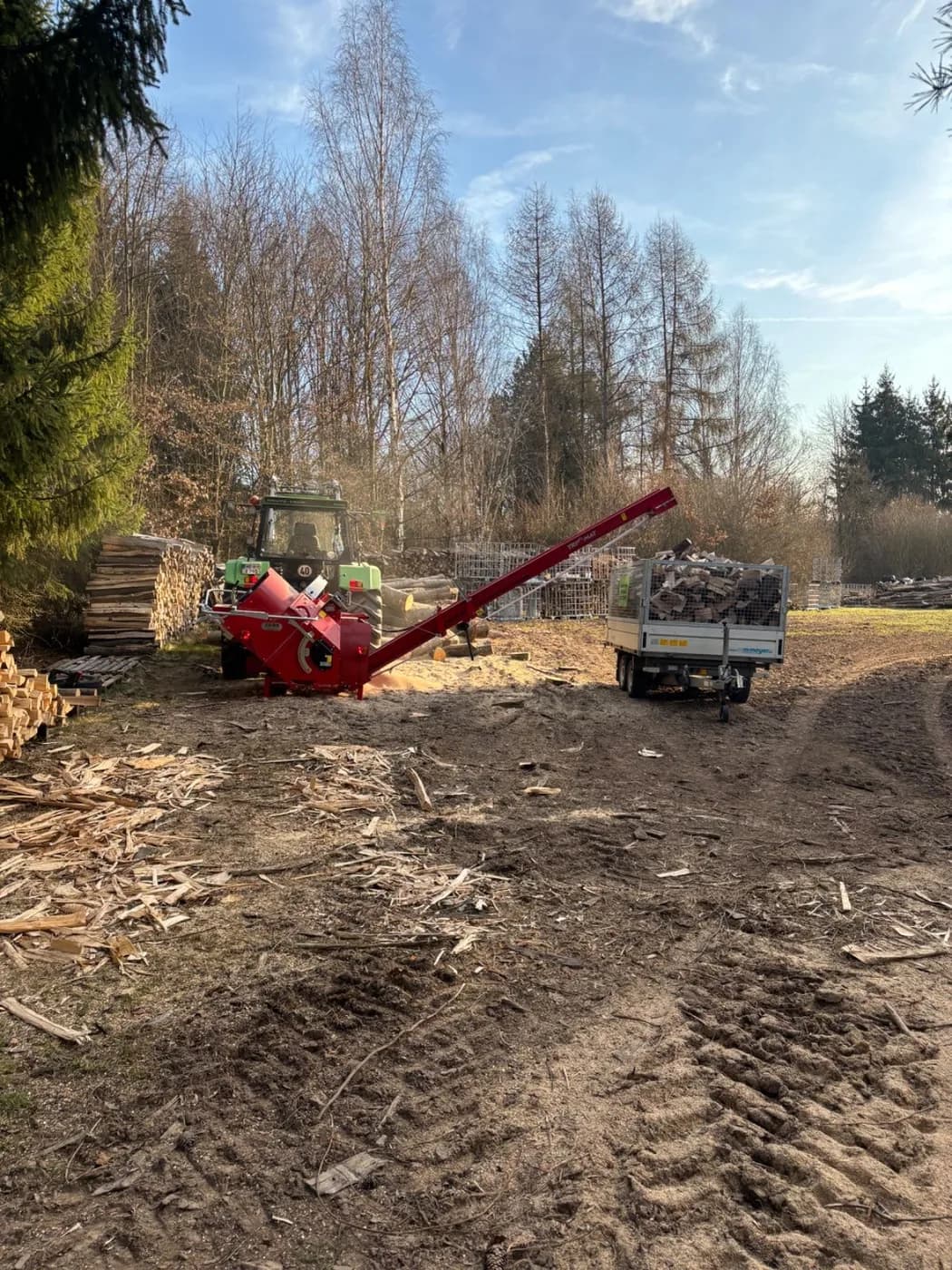 Trommelsäge im Einsatz, das Förderband füllt einen Anhänger